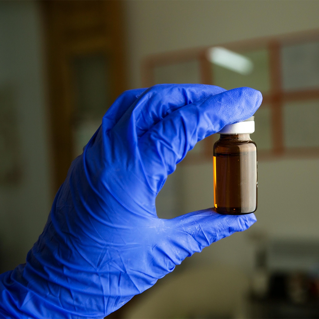 about face medical aesthetics hand with blue glove holding peptide vial